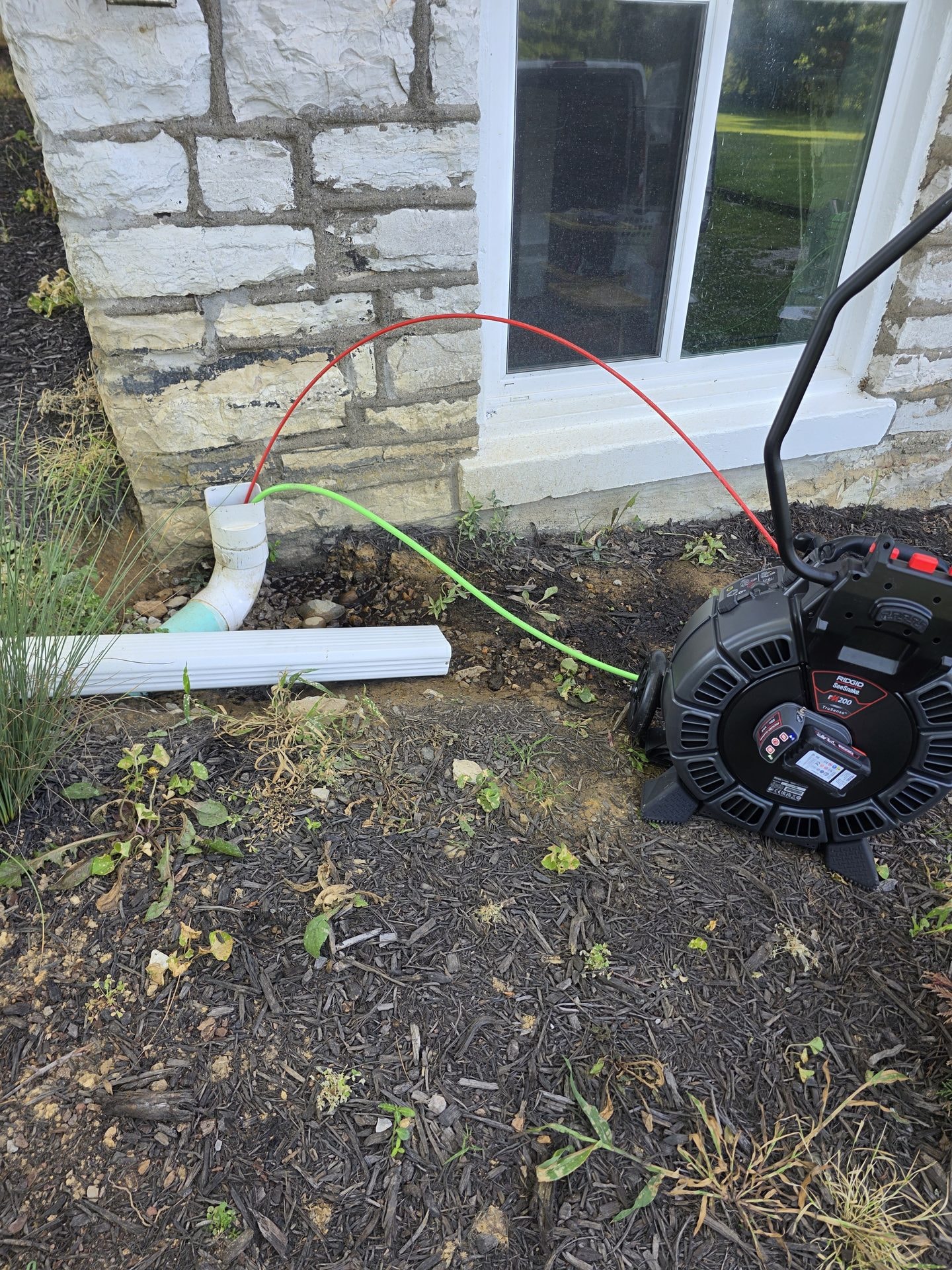 RIDGID SeeSnake camera inspecting an exterior downspout drain line