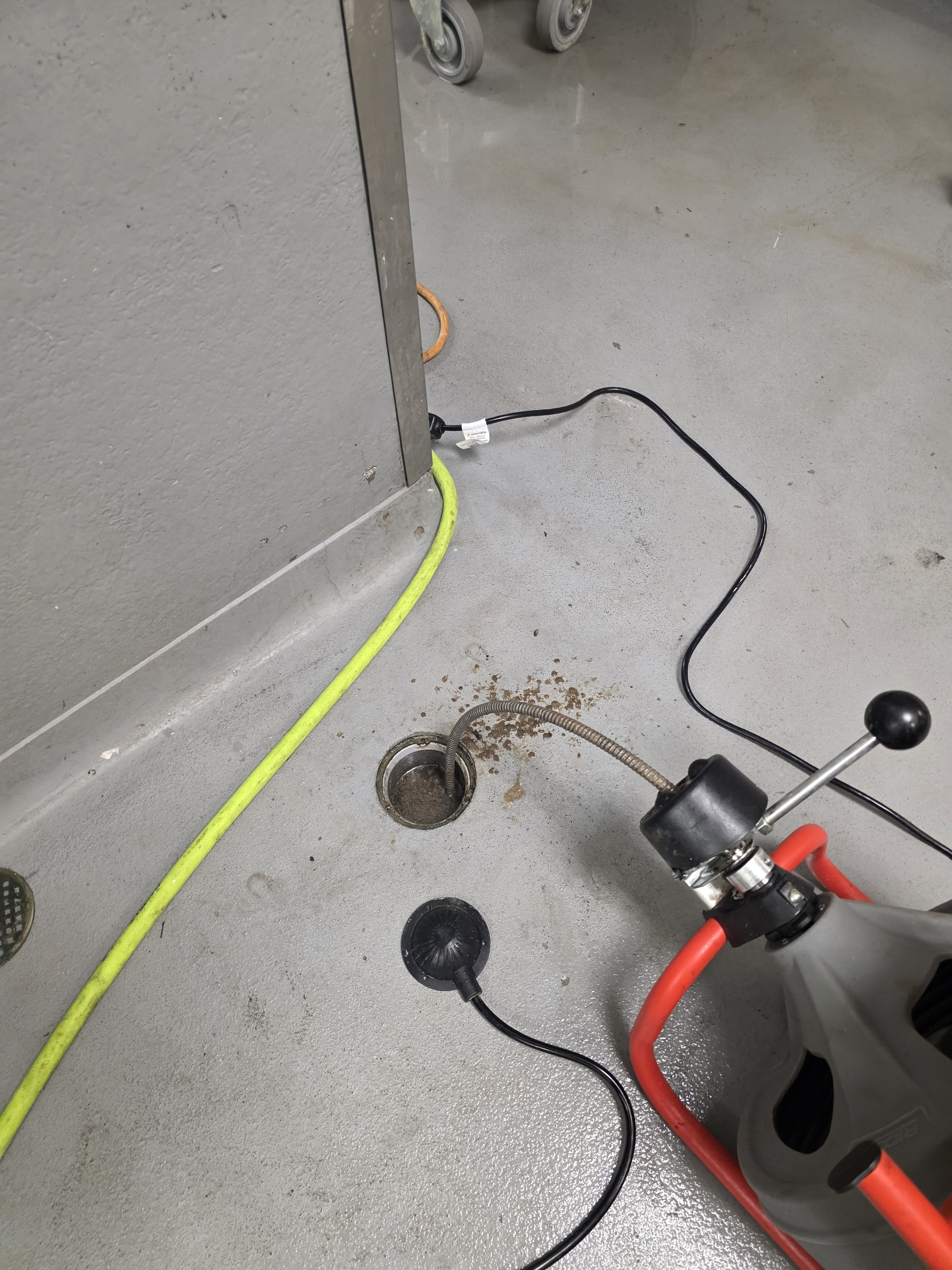 Drain cabling equipment clearing a commercial floor drain