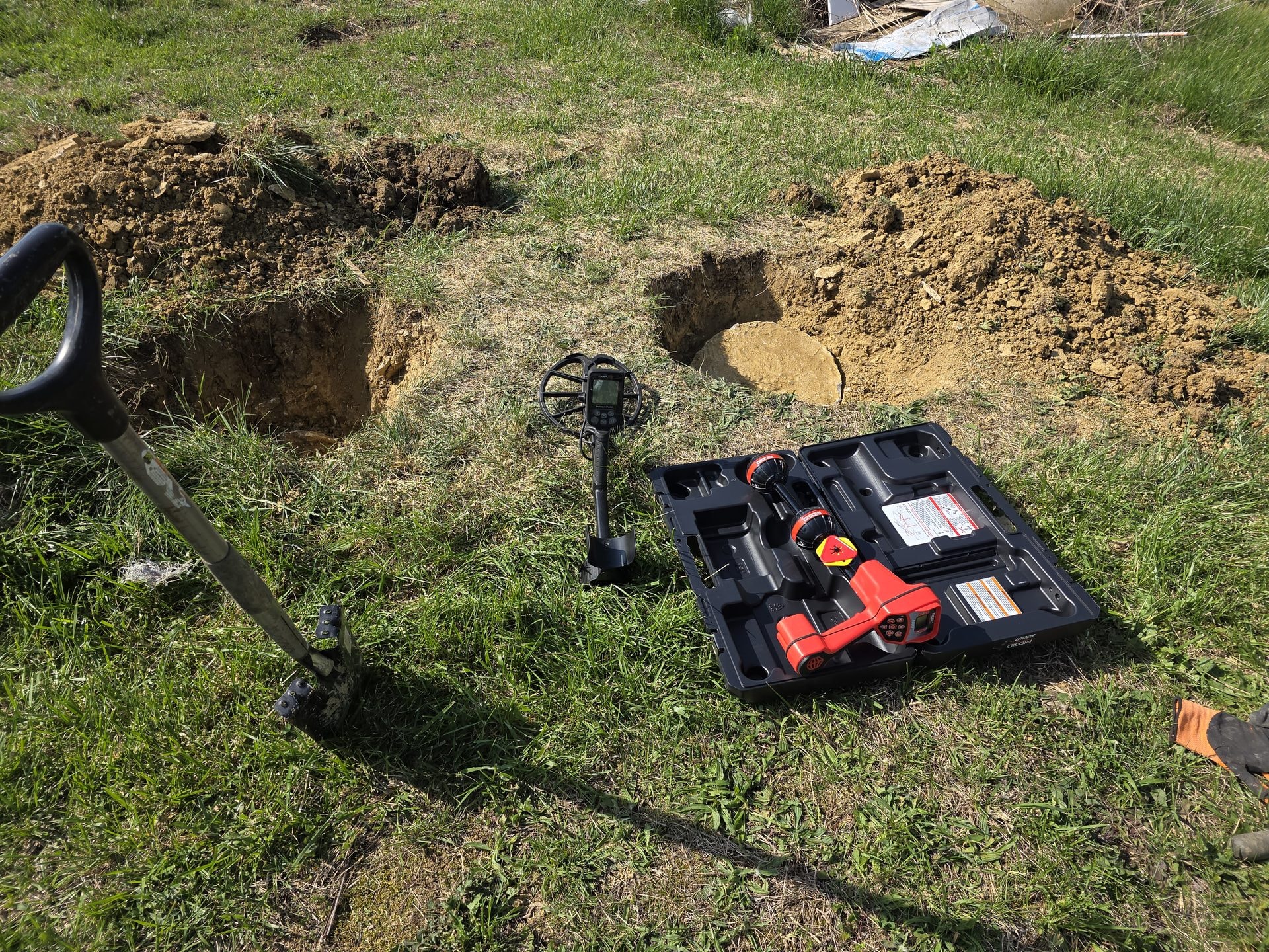 RIDGID line-locating equipment beside excavation test holes
