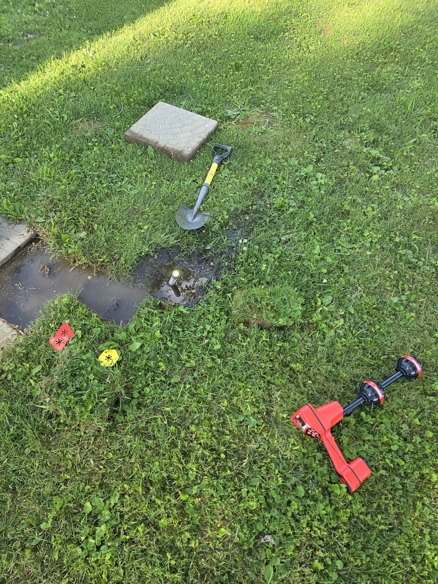 Technician marking an underground drain route for repair